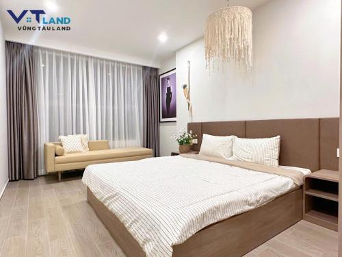 a bedroom with a large bed and a chair at The Sóng Hotel & Apartment Vũng Tàu in Vung Tau