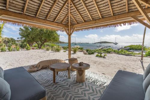 a beach with a couch and tables on the sand at 3-bedrooms Villa 5min from Orient Bay in Cul de Sac