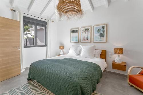 a bedroom with a large bed with a green blanket at 3-bedrooms Villa 5min from Orient Bay in Cul de Sac