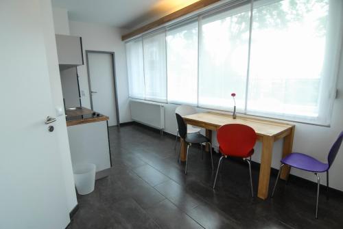 a room with a table and chairs and a television at Petul Apart Hotel Am Ruhrbogen in Bochum