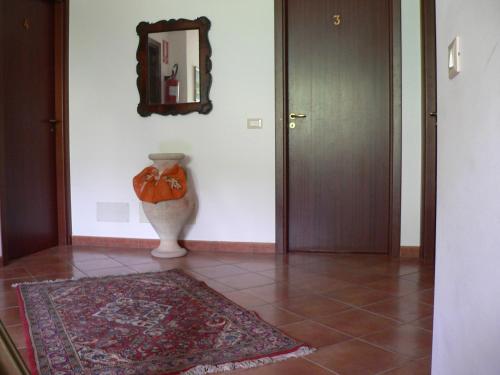 a hallway with a vase and a mirror on a wall at Il Noce Antico in Bisacquino
