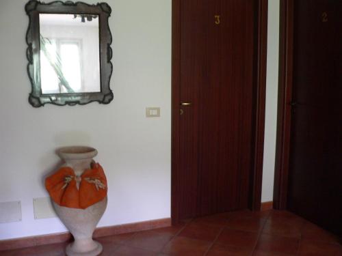 a vase in a room with a mirror on the wall at Il Noce Antico in Bisacquino
