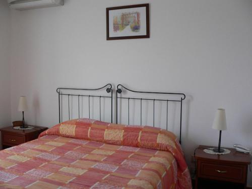 a bed in a bedroom with two nightstands and two lamps at Il Noce Antico in Bisacquino