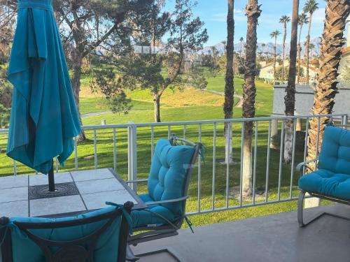 a patio with two chairs and a table and an umbrella at Idyll in the Desert - Immaculate Palm Desert Getaway in Palm Desert