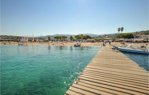 une jetée en bois avec une plage et des bateaux sur l'eau dans l'établissement 3 Bedroom Cozy Home In Porticcio, à Porticcio
