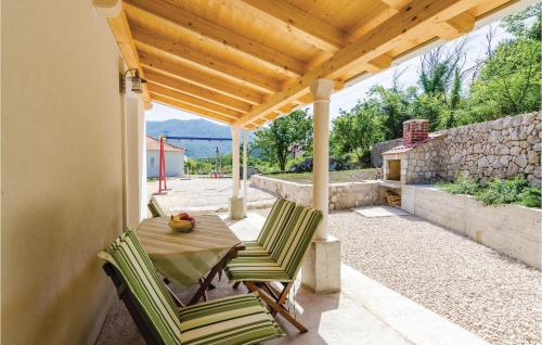 a patio with a table and chairs under a pergola at One-Bedroom Holiday Home In Gruda in Gruda