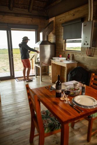 a man standing in a kitchen with a stove at Kuierbos in Gouritzmond