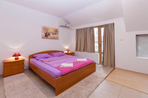 a bedroom with a bed with purple sheets and purple pillows at Apartment Lermontov in Burgas