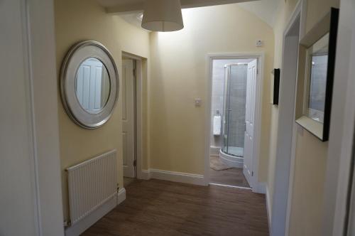 a hallway with a mirror on the wall and a mirror at No. 23 at The Moorings, Chester in Chester