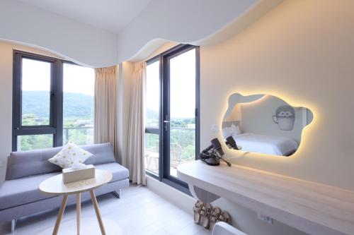 a bedroom with a bed and a couch and a mirror at 宜蘭冬山森活漫漫民宿 in Kung-pu-ch'eng