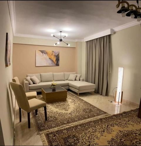 a living room with a couch and a table at All inn in Sheikh Zayed
