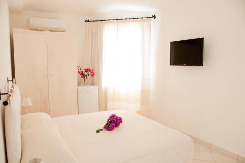 a room with a white bed and a white dresser at Meta Hotel in Santa Teresa Gallura