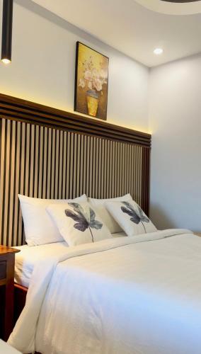 a bedroom with a bed with a wooden headboard at Keang You Boutique Hotel in Phnom Penh