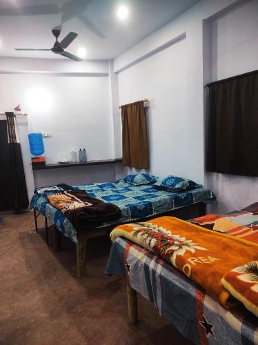 a room with two beds and a ceiling fan at Maa sheetla homestay in Prayagraj