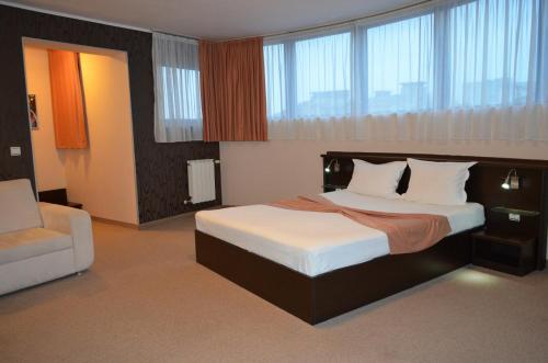 ein Hotelzimmer mit einem Bett und einem Stuhl in der Unterkunft Riverside Family Hotel in Yambol