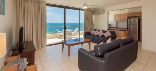 a living room filled with furniture and a balcony at Norfolk Luxury Beachfront Apartments in Gold Coast