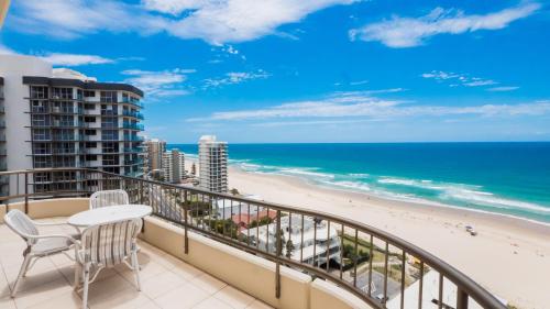 a balcony with a table and chairs and the beach at Norfolk Luxury Beachfront Apartments Gold Coast in Gold Coast