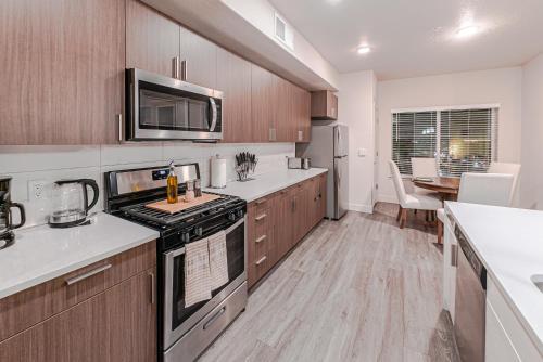 a kitchen with wooden cabinets and a stove top oven at Capital Views 2BR 2BA Pool,Gym,Convention Centre in Salt Lake City
