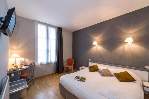 a hotel room with a bed and a desk and a television at Hôtel Miléade Le Domaine de la Blairie - Saumur in Saint-Martin-de-la-Place