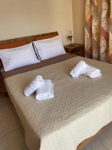 a bed with two white towels on top of it at Rodopi Apartment in Skala Kefalonias