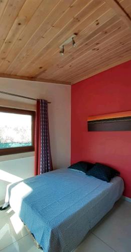 - une chambre avec un lit bleu et un mur rouge dans l'établissement Joli chalet au calme Côte d'Azur, à Valbonne
