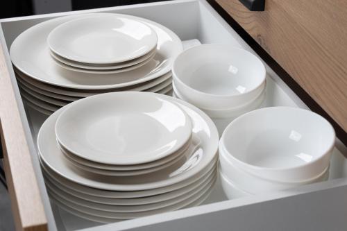 a stack of white plates and bowls in a drawer at UNPLAN Residence suite in Chikuni