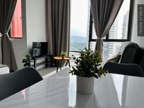 a white table with a potted plant in a living room at Seven Studio - Empire Damansara - Netflix & WiFi in Petaling Jaya