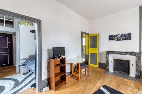 un salon avec une table et une cheminée dans l'établissement Appartement moderne à Sens + 45m² + Parking, à Sens