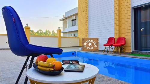 a bowl of fruit on a table next to a pool at Asapin Vanymahal in Rāmnagar