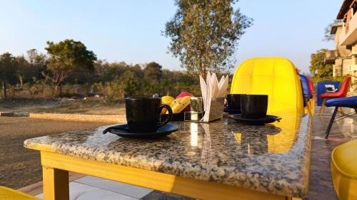 a table with two coffee cups on top of it at Asapin Vanymahal in Rāmnagar