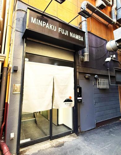 a store front with a sign that reads minrapu full samurai at 民泊富士なんば MinpakuFujiNamba in Osaka