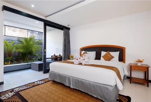 a bedroom with a large bed and a large window at The Kanjeng Suites Kuta Galeria - Bali in Kuta