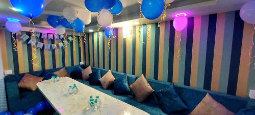 una fiesta con globos y una mesa y un sofá azul en Hotel O Embassy, en Kuch Bihār