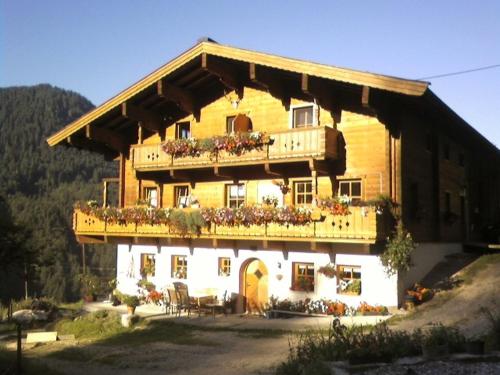 a large wooden building with flowers on the balcony at Riegergut in Unken