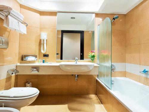 ein Badezimmer mit einem Waschbecken, einem WC und einer Badewanne in der Unterkunft Hotel IMPERATORI in Rom