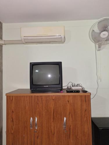 una pequeña televisión en la parte superior de un armario de madera en ป่ากล้วยริเวอร์ไซด์รีสอร์ท, en Ban Muang Len