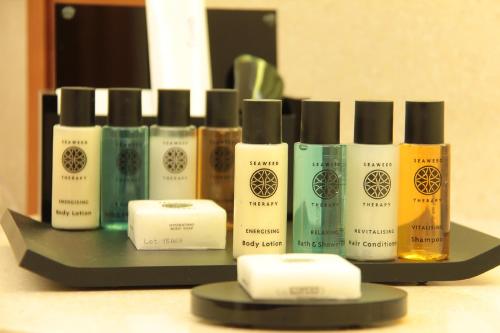 a group of bottles of hair products on a shelf at Thousand Nights Hotel Amman - فندق ثاوزند نايتس عمان in Amman