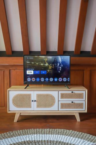 a flat screen tv sitting on top of a cabinet at d' Omah Afi 1 in Jarakan