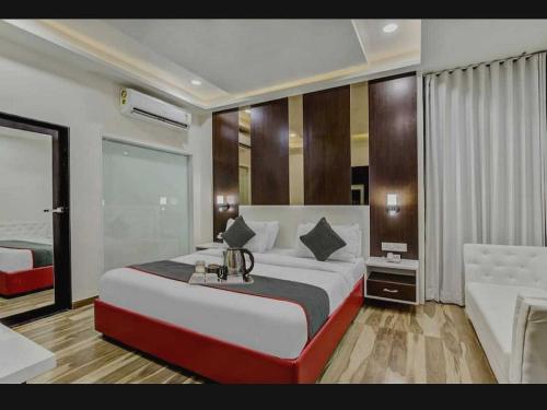a bedroom with a large bed and a couch at Hotel O Raas Near Near Paschim Vihar in New Delhi