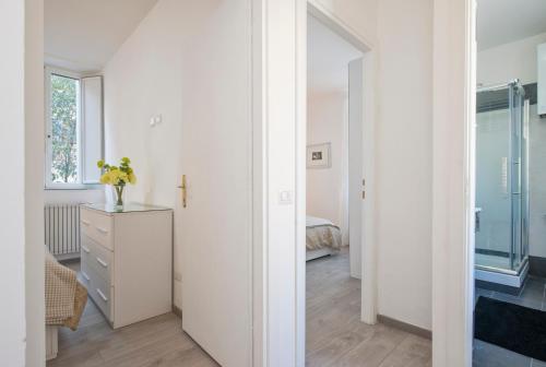 ein weißes Zimmer mit einer Kommode und einem Spiegel in der Unterkunft Vatican Holiday Apartment 317 in Rom