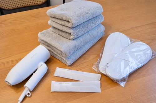 einen Tisch mit einem Haufen Handtücher auf dem Tisch in der Unterkunft OSAKA COZY HOUSE For Family & Group 2bedroom in Takaishi
