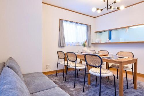 a living room with a couch and a table and chairs at OSAKA COZY HOUSE For Family & Group 2bedroom in Takaishi