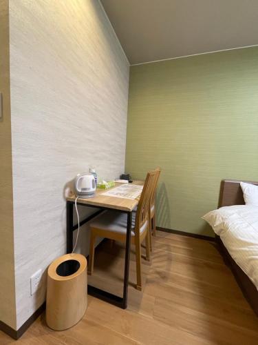a small room with a table and a bed at Guest House Goettingen in Kyoto