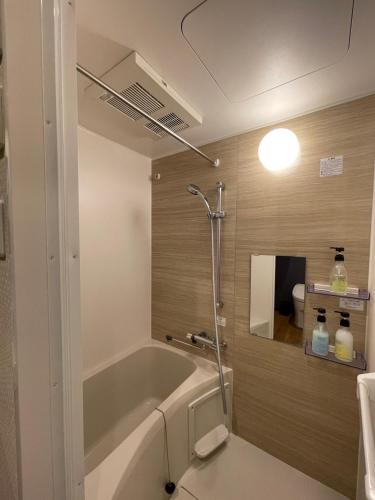 a bathroom with a bath tub and a sink at Guest House Goettingen in Kyoto