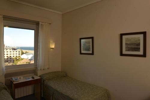 a hotel room with a bed and a window at Comodoro Hotel in Comodoro Rivadavia