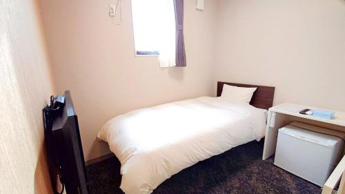 a small bedroom with a white bed and a window at Ｓｗｉｍｍｙ Ｉｎｎ Ｏｎａｇａｗａ - Vacation STAY 44062v in Onagawa