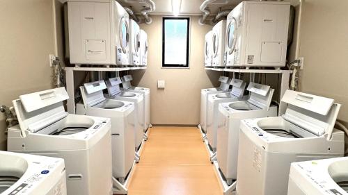 a laundry room with white washers and dryers on shelves at Ｓｗｉｍｍｙ Ｉｎｎ Ｏｎａｇａｗａ - Vacation STAY 44062v in Onagawa