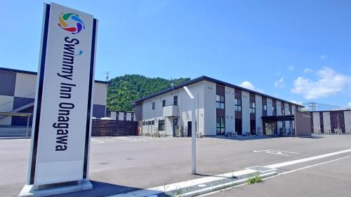 a sign in a parking lot in front of a building at Ｓｗｉｍｍｙ Ｉｎｎ Ｏｎａｇａｗａ - Vacation STAY 44062v in Onagawa