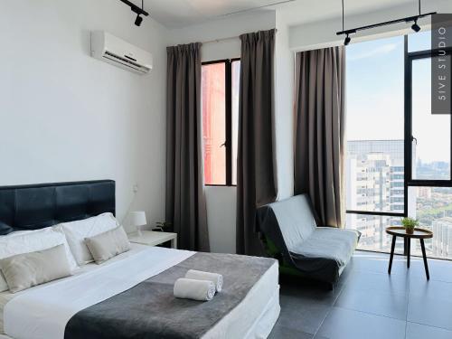 a bedroom with a large bed and a chair at Five Studio - Empire Damansara in Petaling Jaya
