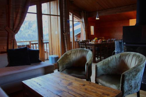 a living room with two chairs and a wooden table at Cosy 4 bedroom chalet with hot tub (Chalet Velours) in Saint-Marcel